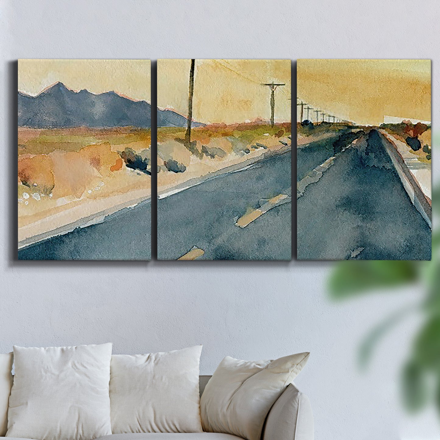 Three-panel canvas wall art featuring empty highway stretching through landscape, displayed in a living room above a sofa.