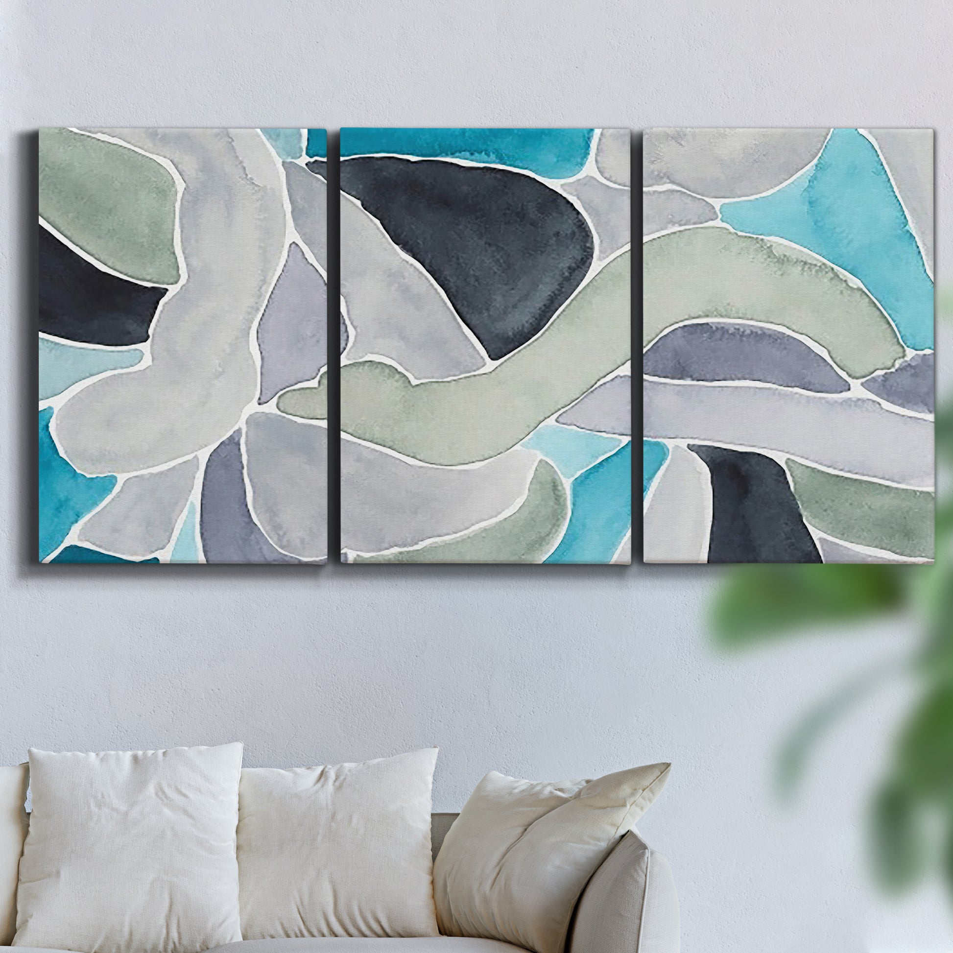 Three-panel canvas wall art featuring subtle abstract billowing color layers, displayed in a living room above a sofa.