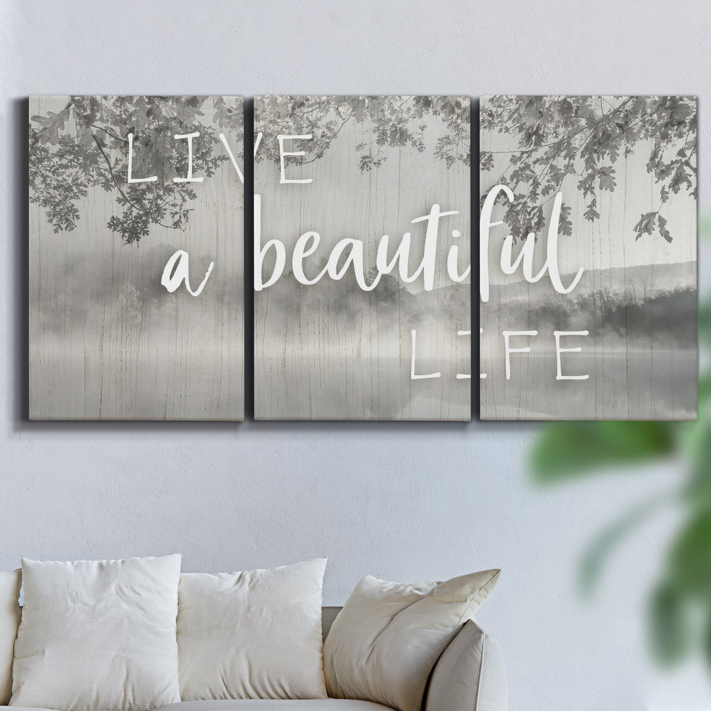 Three-panel canvas wall art featuring uplifting life themed typography, displayed in a living room above a sofa.