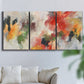 Three-panel canvas wall art featuring abstract floral color composition, displayed in a living room above a sofa.