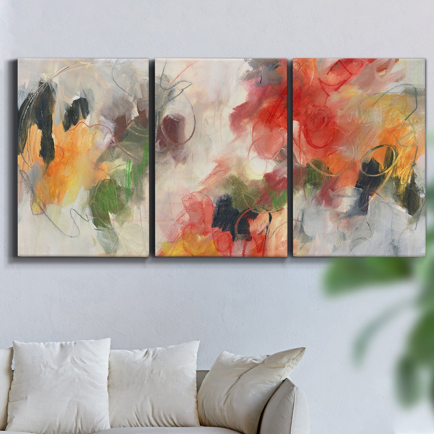 Three-panel canvas wall art featuring abstract floral color composition, displayed in a living room above a sofa.