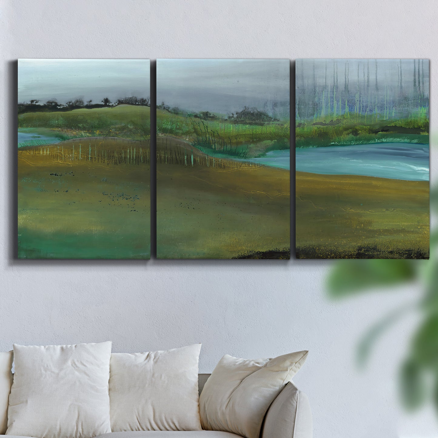 Three-panel canvas wall art featuring quiet contemplative landscape scene, displayed in a living room above a sofa.