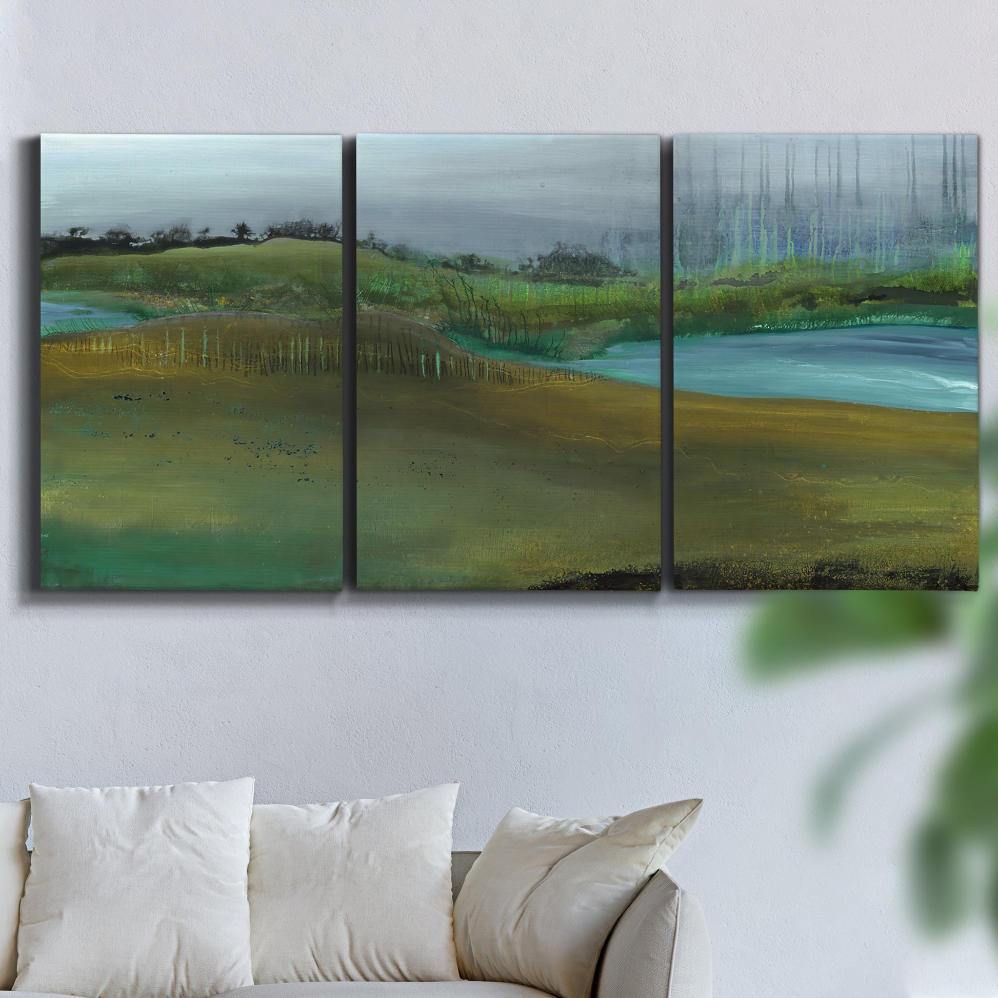 Three-panel canvas wall art featuring quiet contemplative landscape scene, displayed in a living room above a sofa.