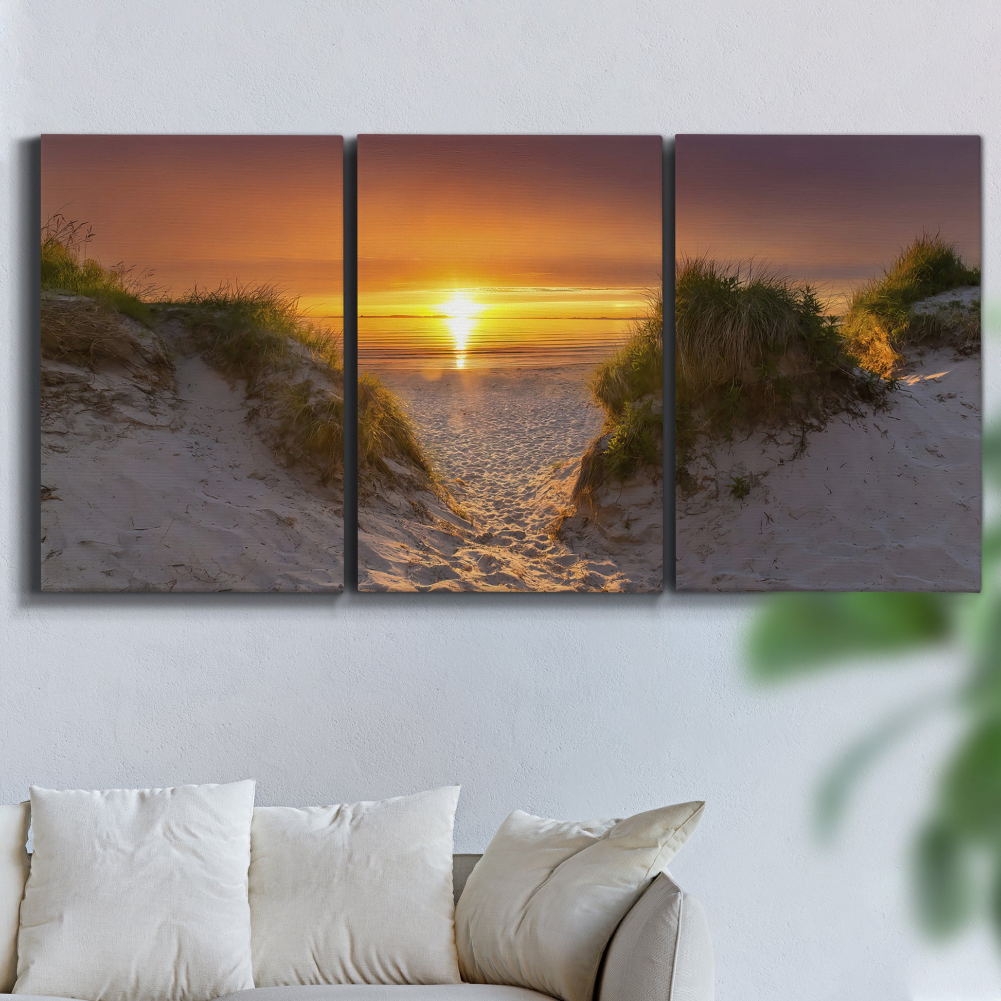 Three-panel canvas wall art featuring sunlit tropical path through greenery, displayed in a living room above a sofa.