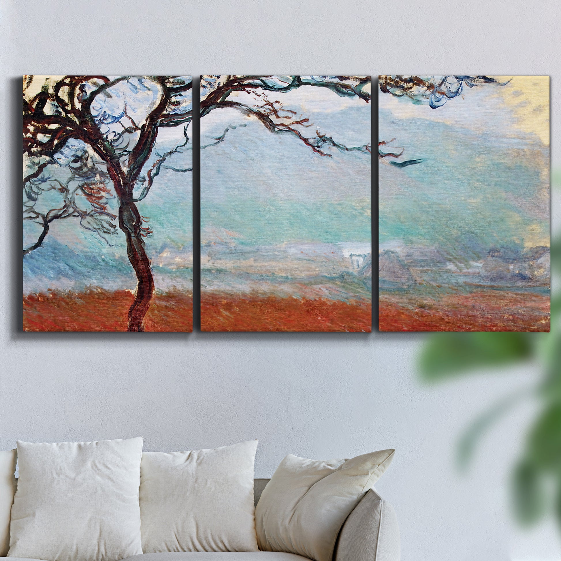 Three-panel canvas wall art featuring coastal trees at evening light, displayed in a living room above a sofa.