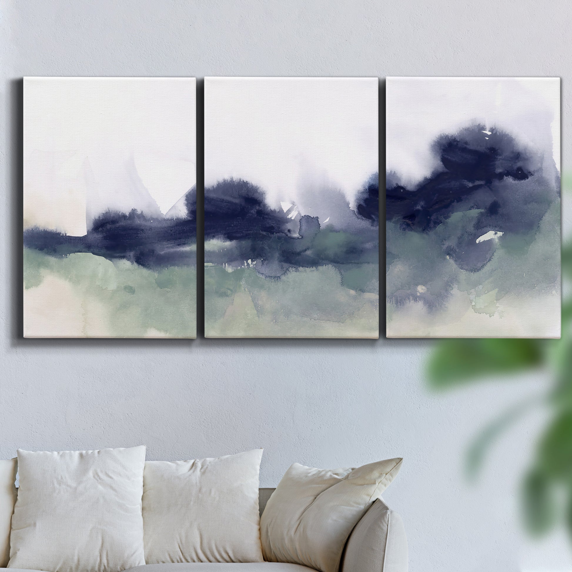 Three-panel canvas wall art featuring misty abstract lake watercolor, displayed in a living room above a sofa.