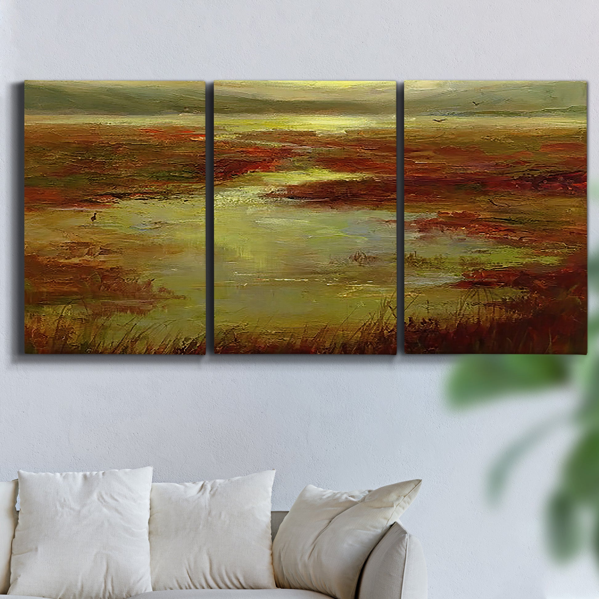 Three-panel canvas wall art featuring coastal shoreline with warm light, displayed in a living room above a sofa.