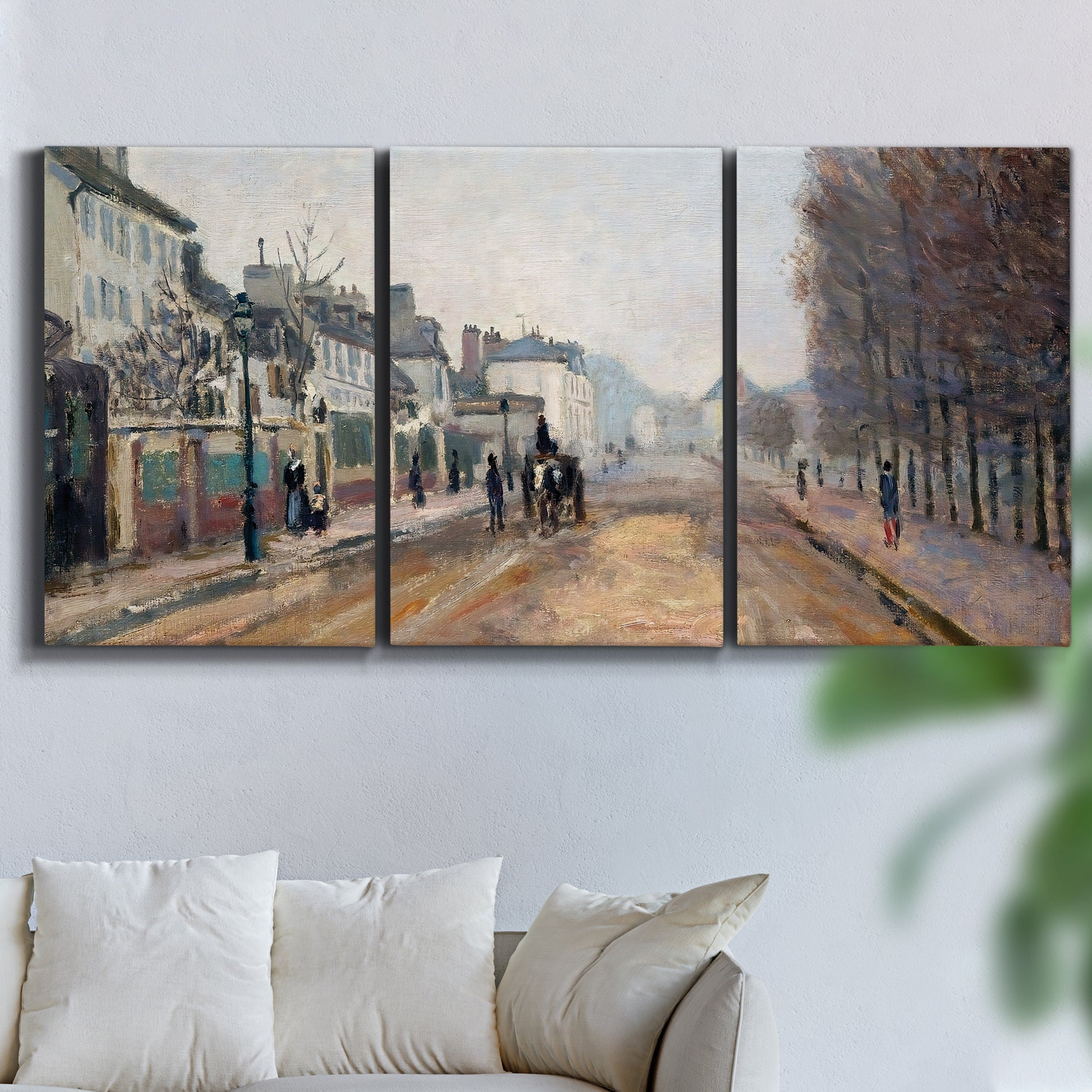 Three-panel canvas wall art featuring tree lined boulevard in town, displayed in a living room above a sofa.