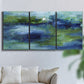 Three-panel canvas wall art featuring flowing blue abstract watercolor, displayed in a living room above a sofa.