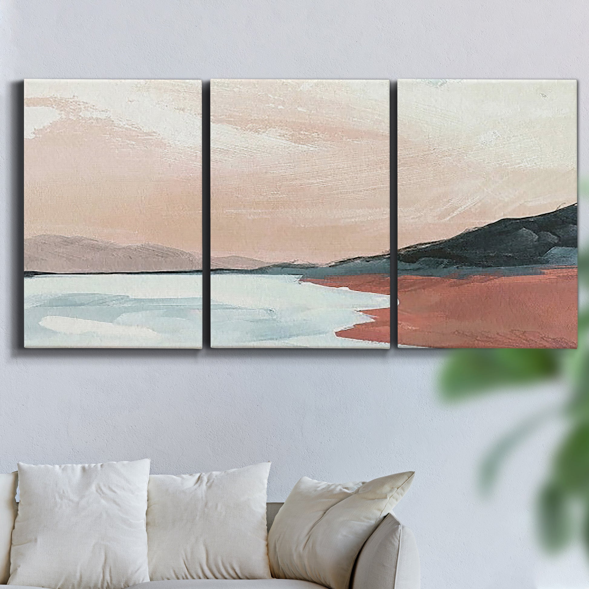 Three-panel canvas wall art featuring quiet coastline with distant horizon, displayed in a living room above a sofa.