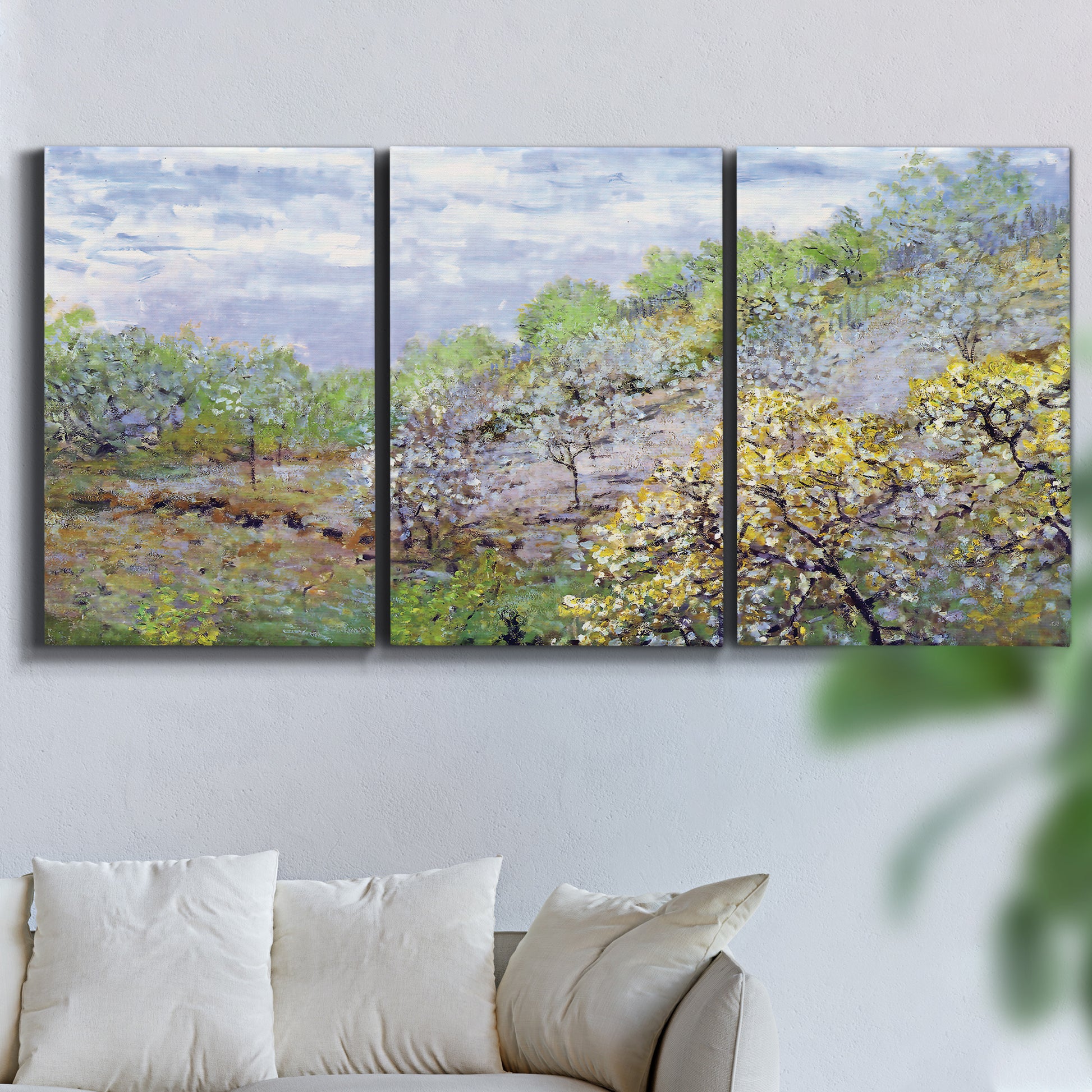 Three-panel canvas wall art featuring spring orchard in full bloom, displayed in a living room above a sofa.