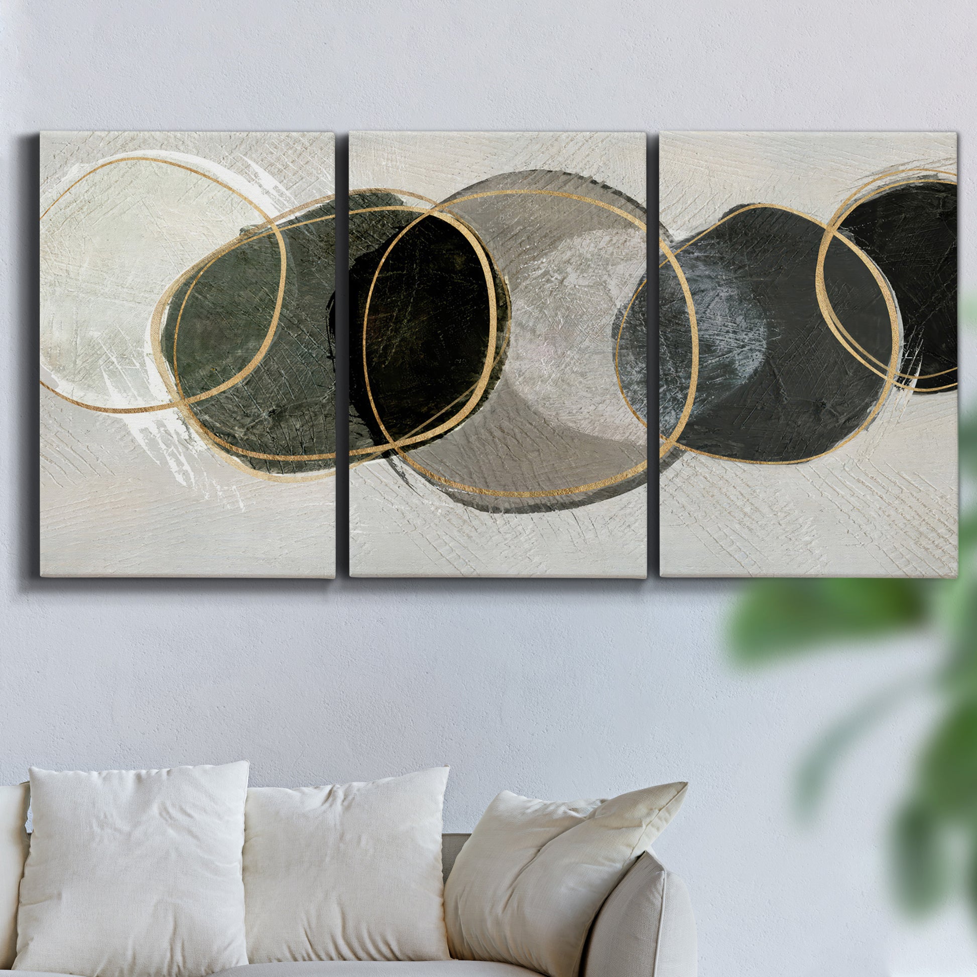 Three-panel canvas wall art featuring smooth abstract river stone forms, displayed in a living room above a sofa.