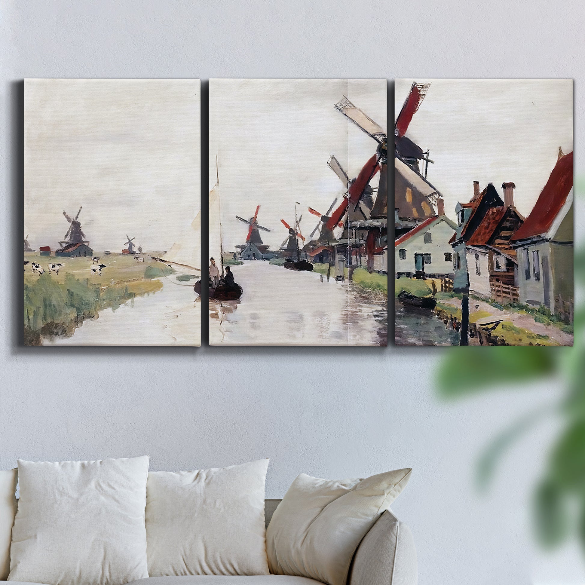 Three-panel canvas wall art featuring windmills beside calm water, displayed in a living room above a sofa.