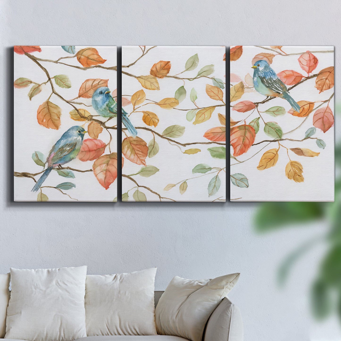 Three-panel canvas wall art featuring decorative bird trio illustration, displayed in a living room above a sofa.