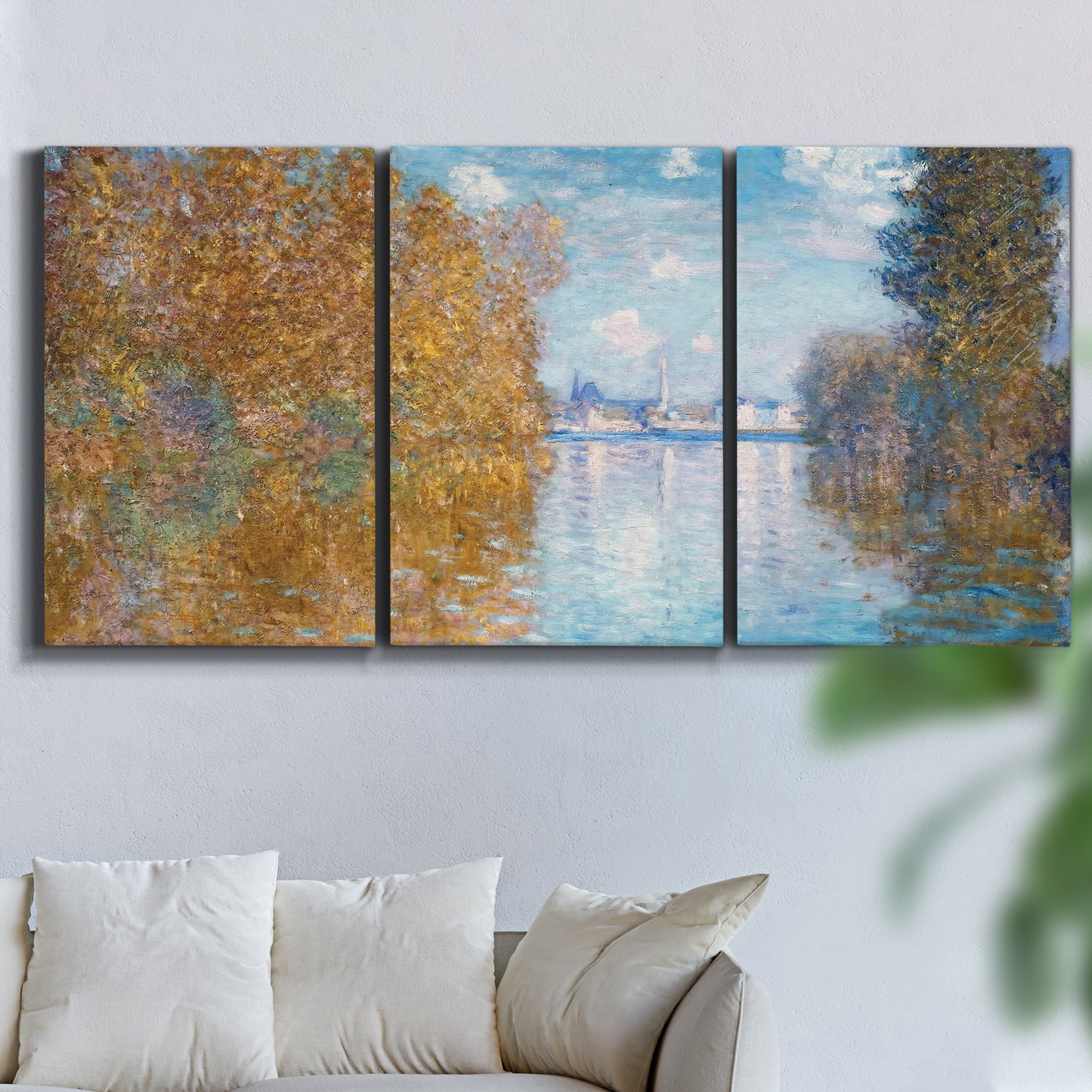 Three-panel canvas wall art featuring autumn landscape with glowing foliage, displayed in a living room above a sofa.