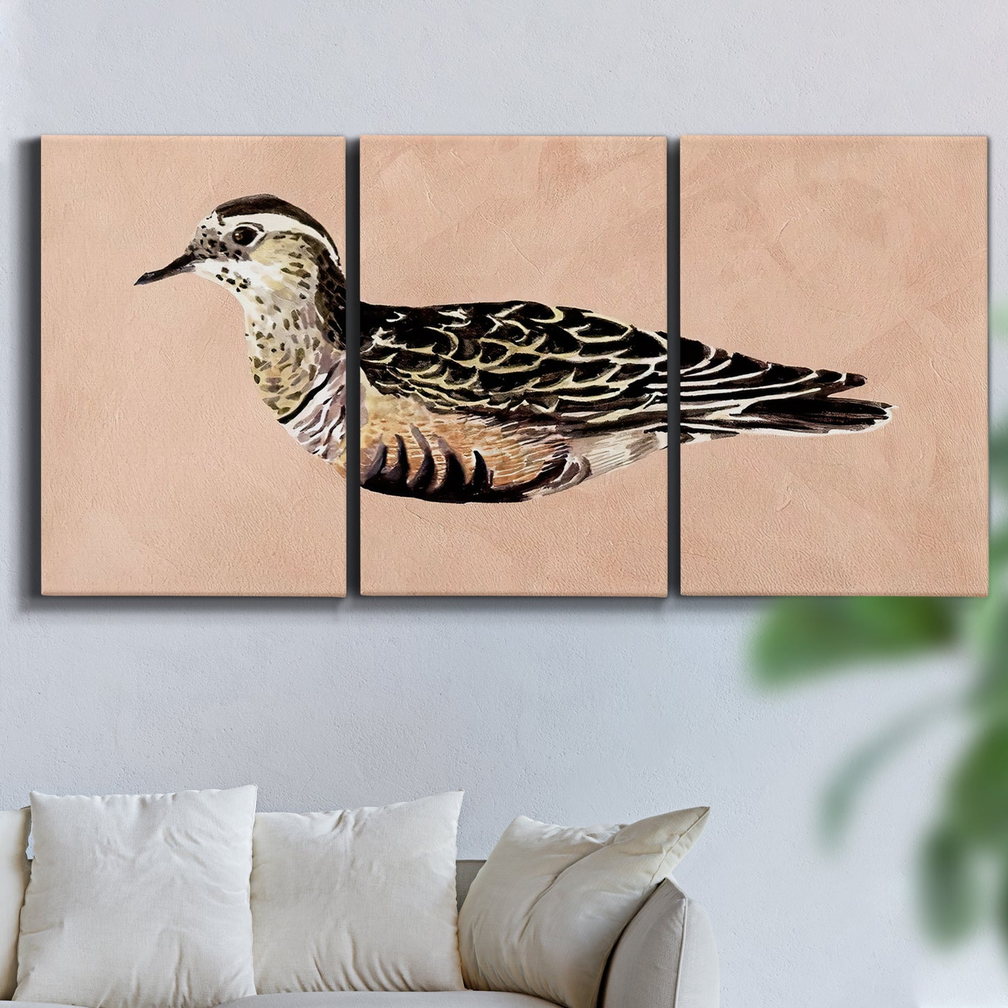 Three-panel canvas wall art featuring coastal bird illustration, displayed in a living room above a sofa.
