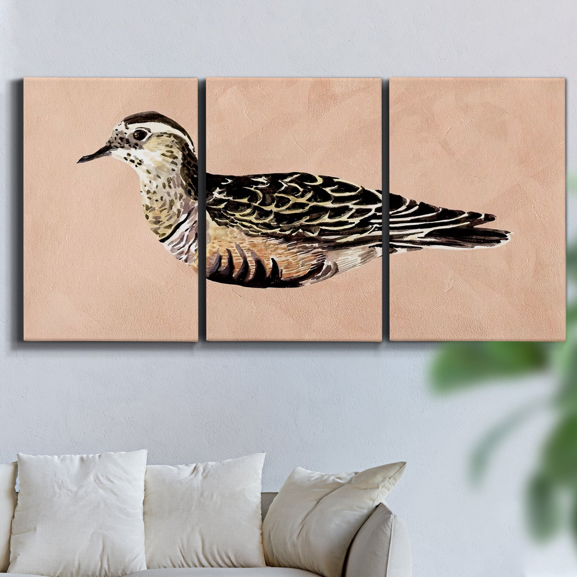 Three-panel canvas wall art featuring coastal bird illustration, displayed in a living room above a sofa.