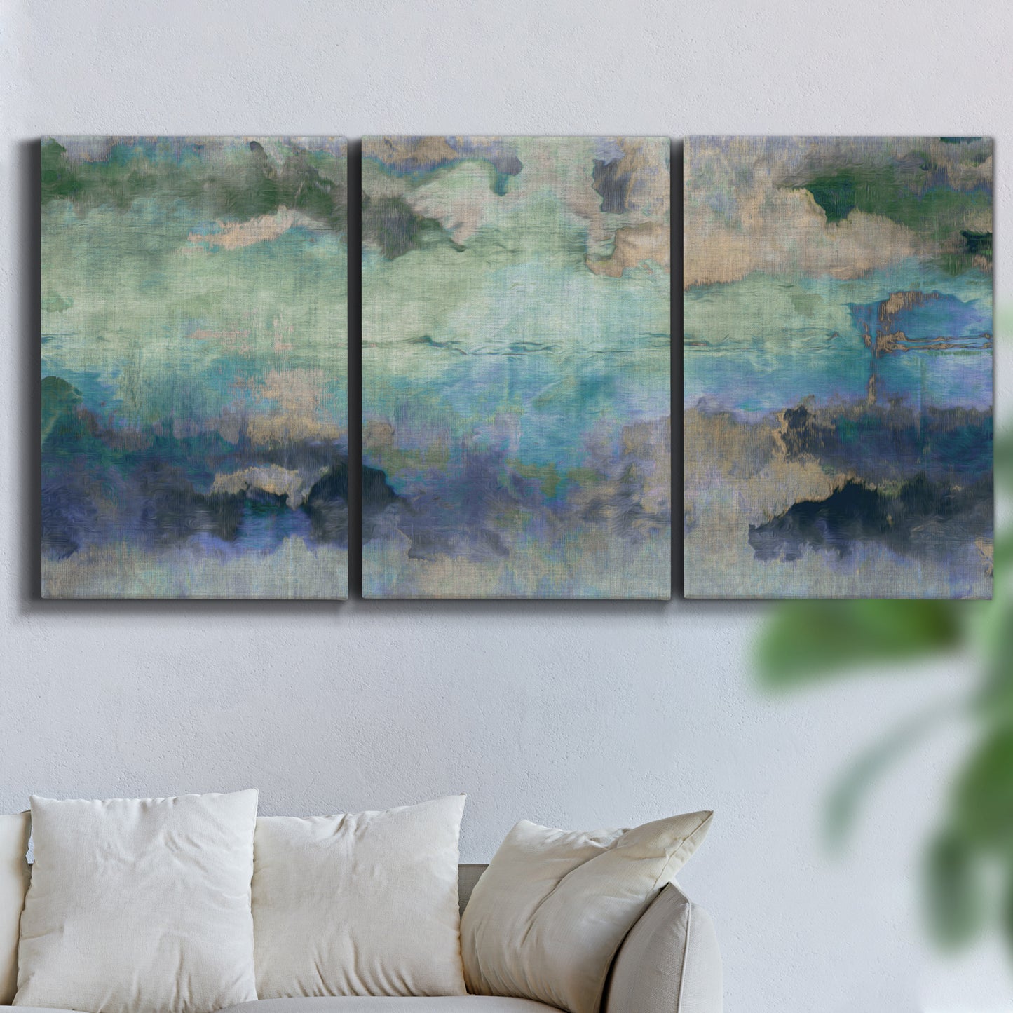 Three-panel canvas wall art featuring cool dreamy abstraction, displayed in a living room above a sofa.