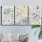 Three-panel canvas wall art featuring flowing abstract watercolor, displayed in a living room above a sofa.