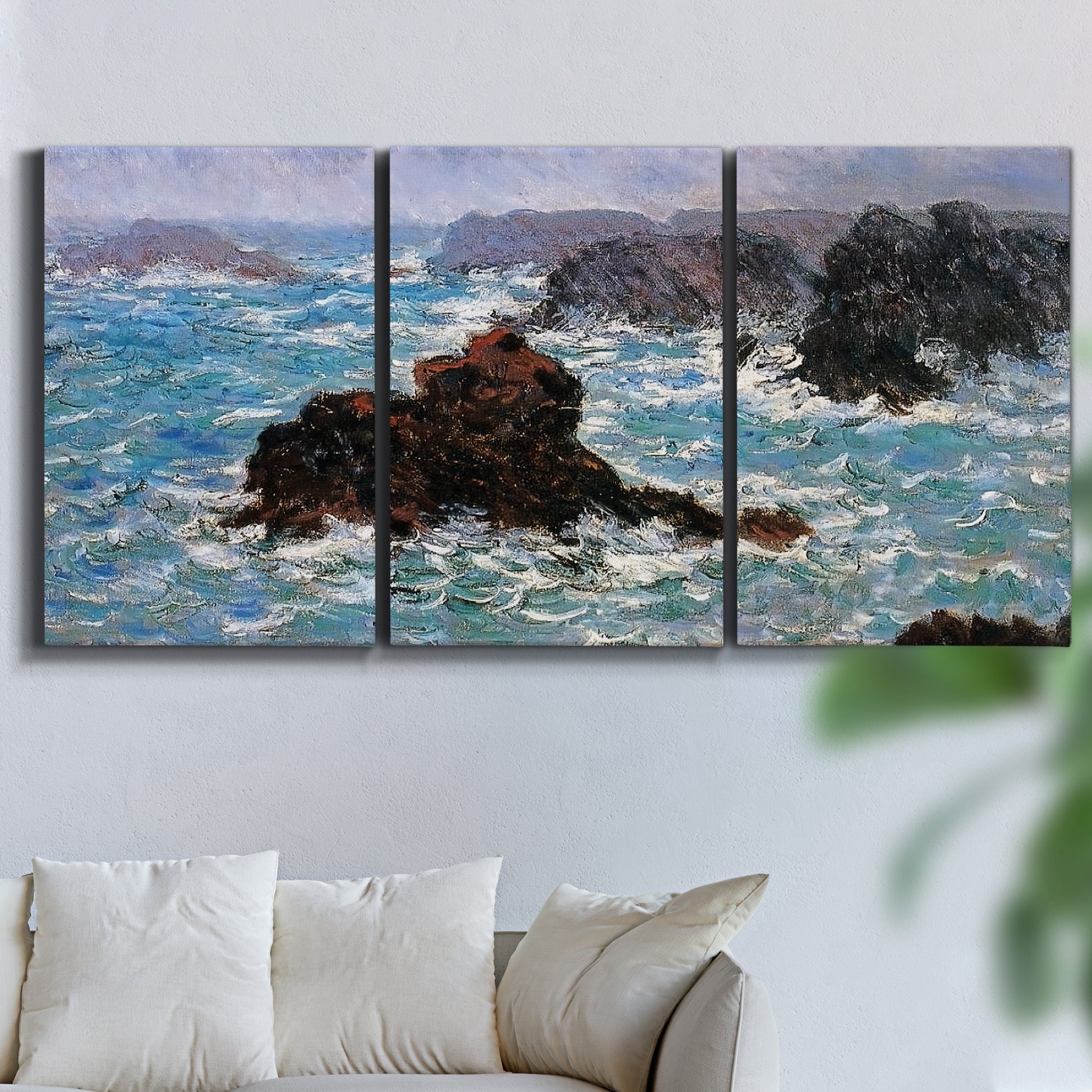 Three-panel canvas wall art featuring storm waves battering rocky coast, displayed in a living room above a sofa.