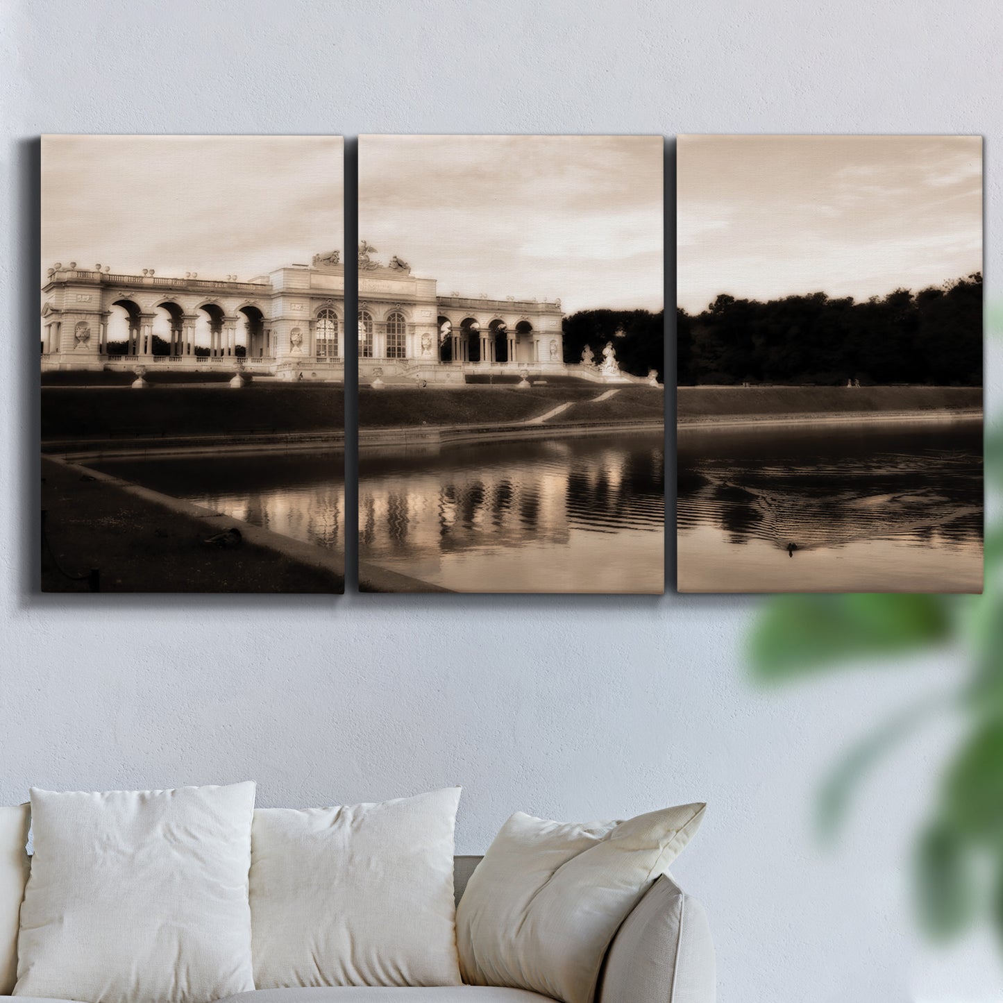 Three-panel canvas wall art featuring monochrome historic pavilion photograph, displayed in a living room above a sofa.