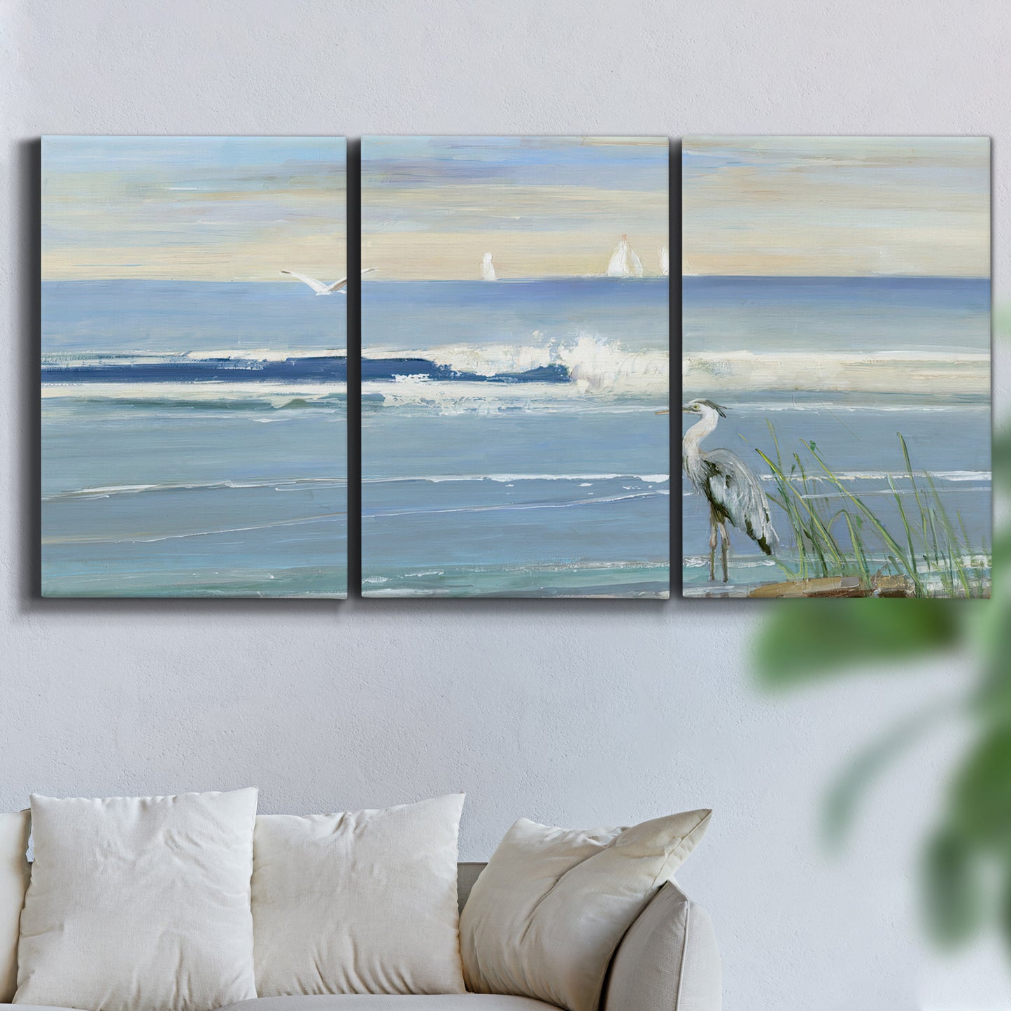 Three-panel canvas wall art featuring sunrise reflecting across bay waters, displayed in a living room above a sofa.