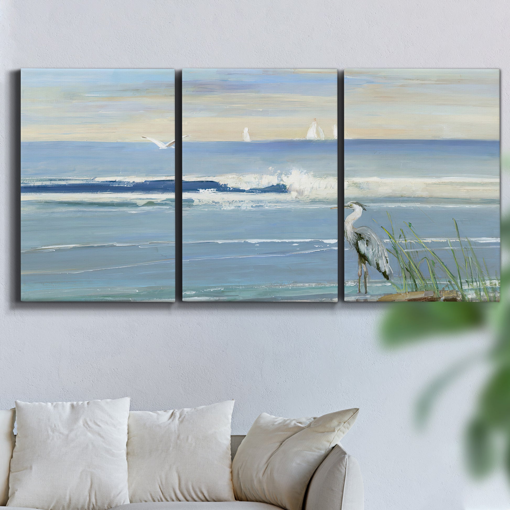 Three-panel canvas wall art featuring sunrise reflecting across bay waters, displayed in a living room above a sofa.