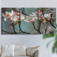 Three-panel canvas wall art featuring dogwood blossoms in spring photograph, displayed in a living room above a sofa.