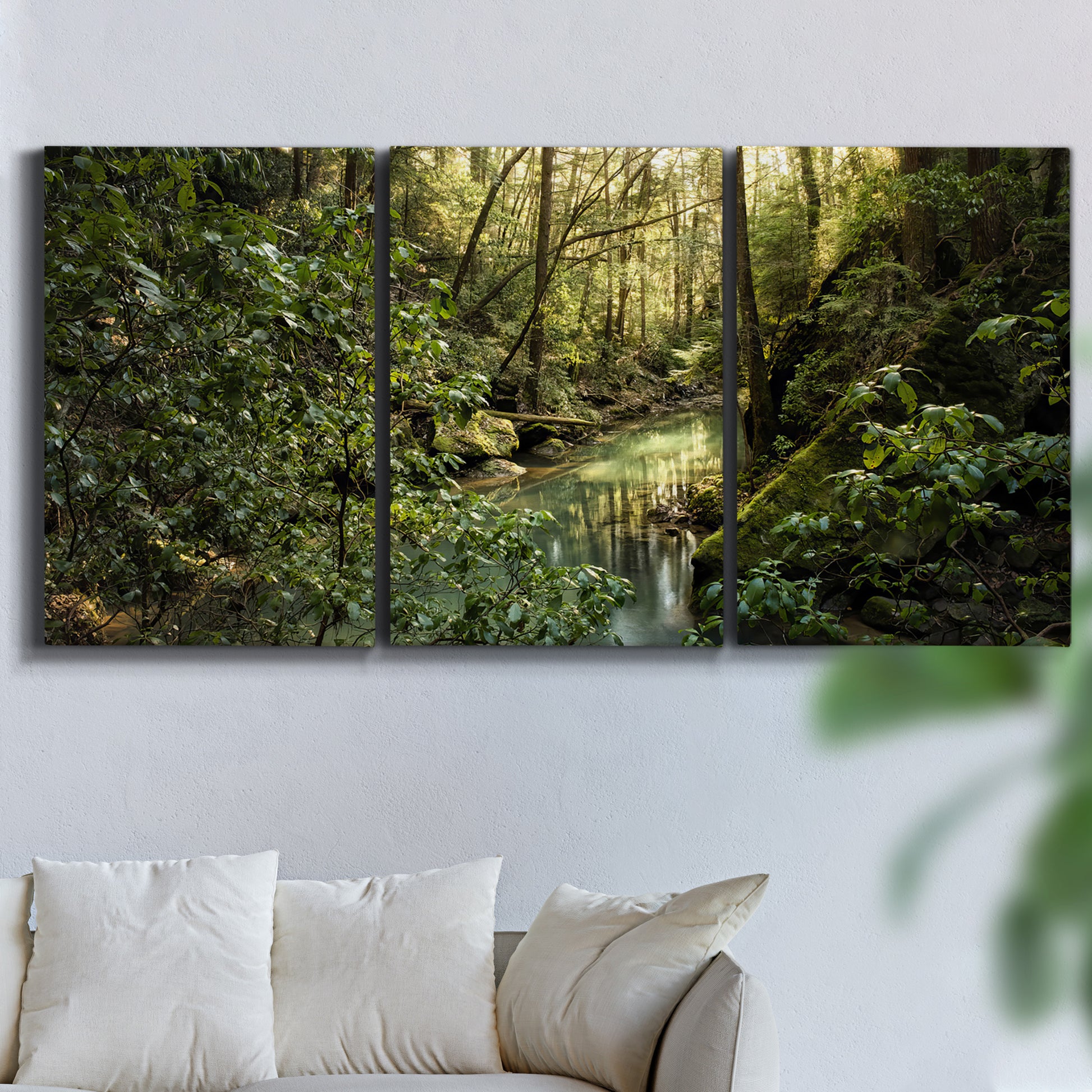 Three-panel canvas wall art featuring sun filtered woodland photograph, displayed in a living room above a sofa.
