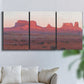 Three-panel canvas wall art featuring red rock desert formations at dusk, displayed in a living room above a sofa.