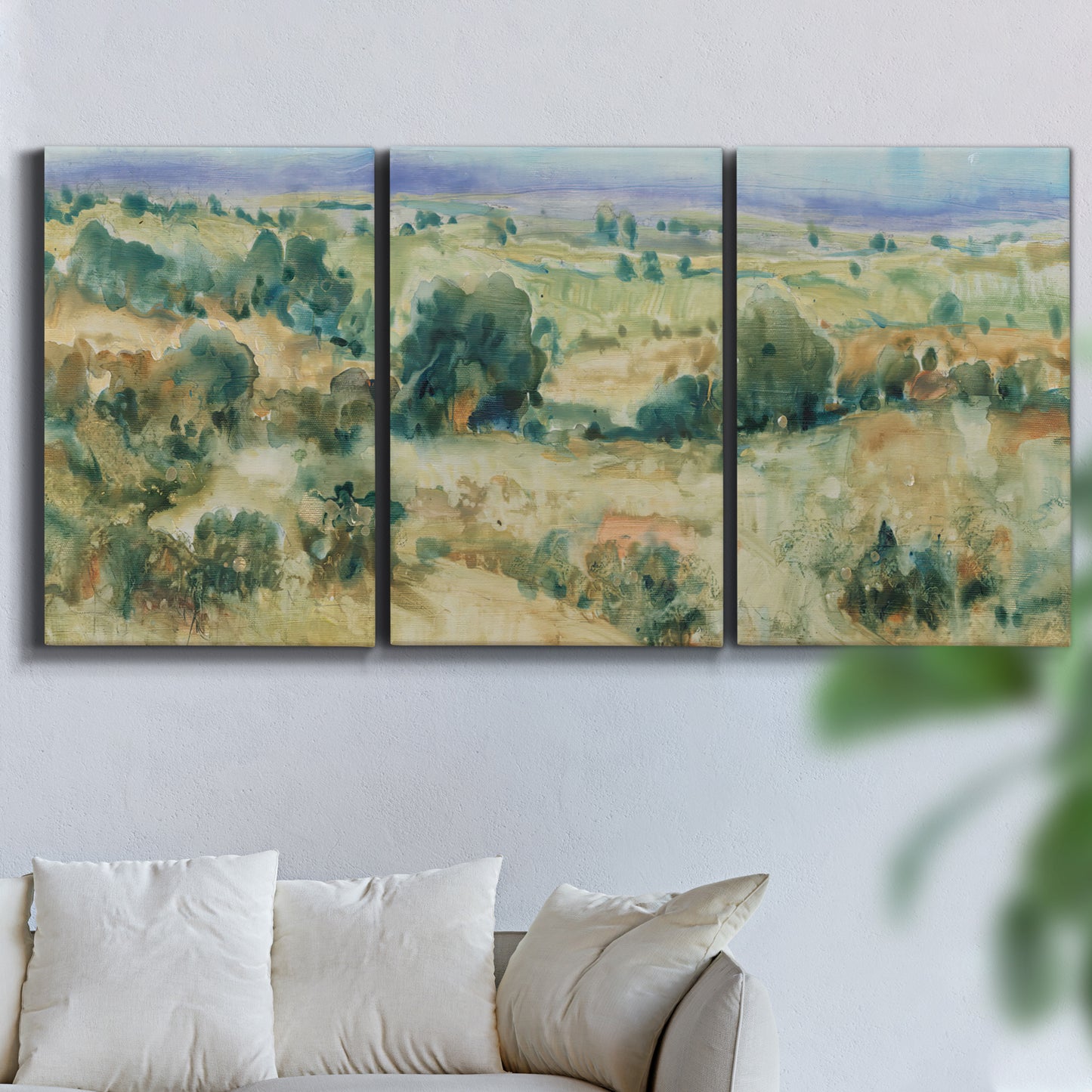 Three-panel canvas wall art featuring lavender sky over quiet landscape, displayed in a living room above a sofa.