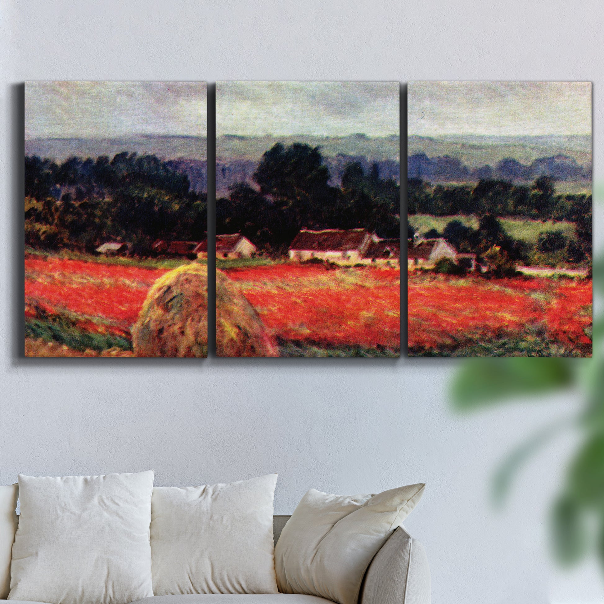 Three-panel canvas wall art featuring red poppy field near barn, displayed in a living room above a sofa.