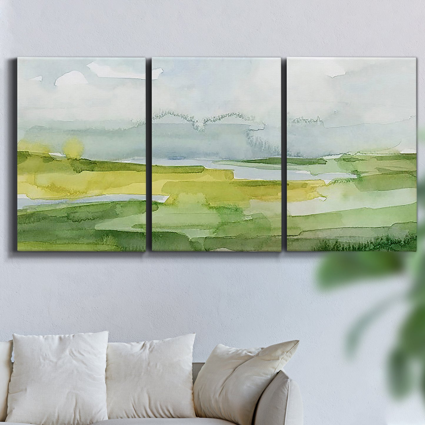 Three-panel canvas wall art featuring lowland wetlands with reflective water, displayed in a living room above a sofa.