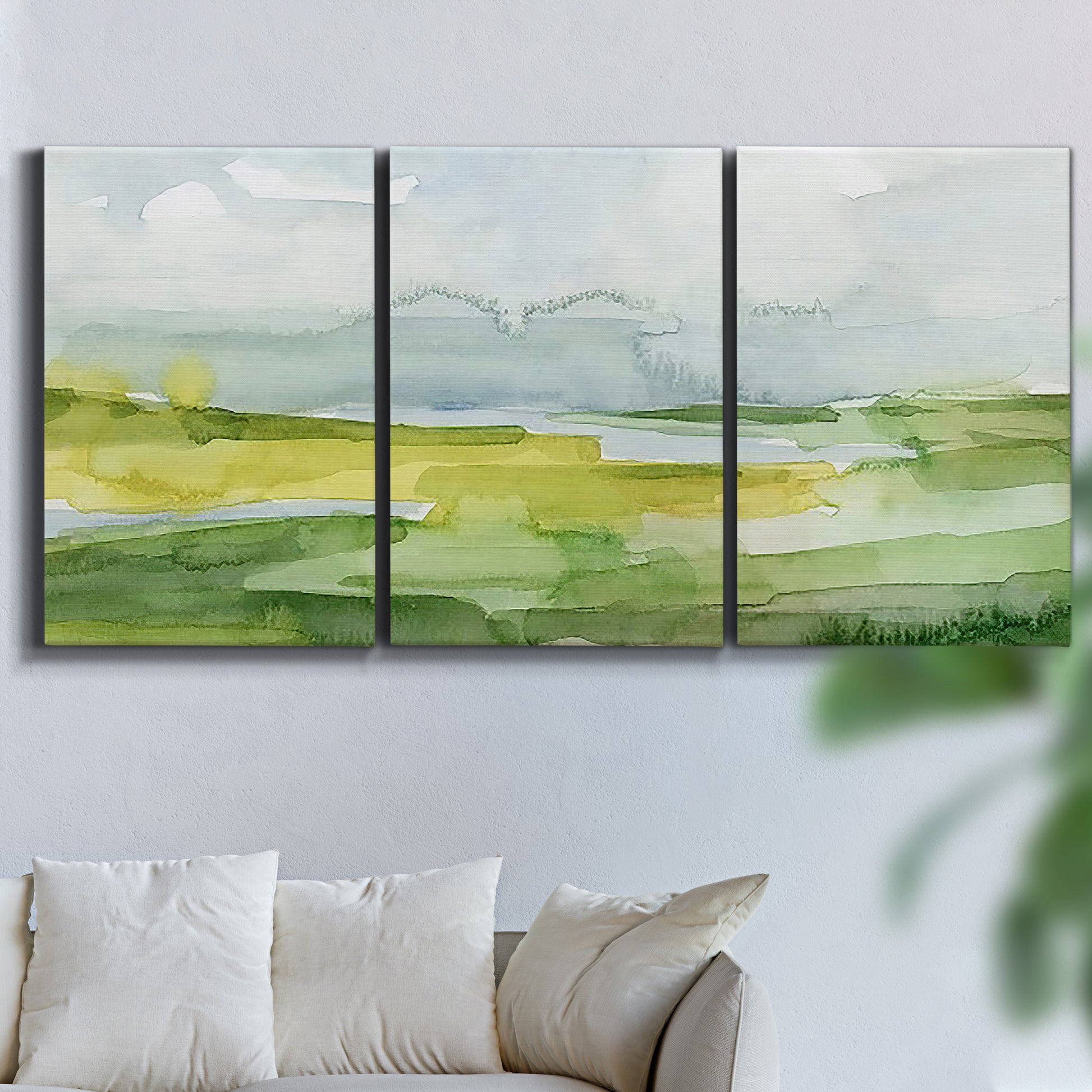 Three-panel canvas wall art featuring lowland wetlands with reflective water, displayed in a living room above a sofa.