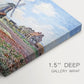 Canvas art print of colorful rows of tulip fields leading toward distant windmill, highlighting texture and gallery-wrapped edges