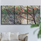Three-panel canvas wall art featuring riverside park with figures and trees, displayed in a living room above a sofa.