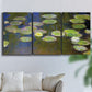 Three-panel canvas wall art featuring yellow and white water lilies, displayed in a living room above a sofa.