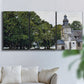 Three-panel canvas wall art featuring chapel building in rural setting, displayed in a living room above a sofa.