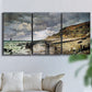 Three-panel canvas wall art featuring sunset beach with glowing sky, displayed in a living room above a sofa.