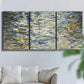 Three-panel canvas wall art featuring abstract water surface reflections, displayed in a living room above a sofa.