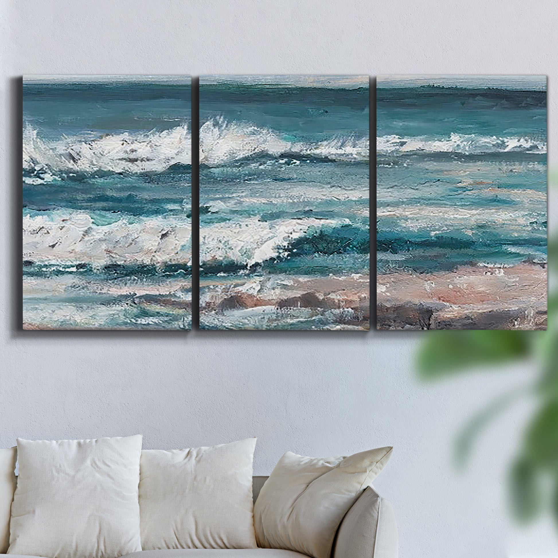 Three-panel canvas wall art featuring crashing ocean waves along shoreline, displayed in a living room above a sofa.
