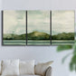 Three-panel canvas wall art featuring riverbank watercolor landscape, displayed in a living room above a sofa.
