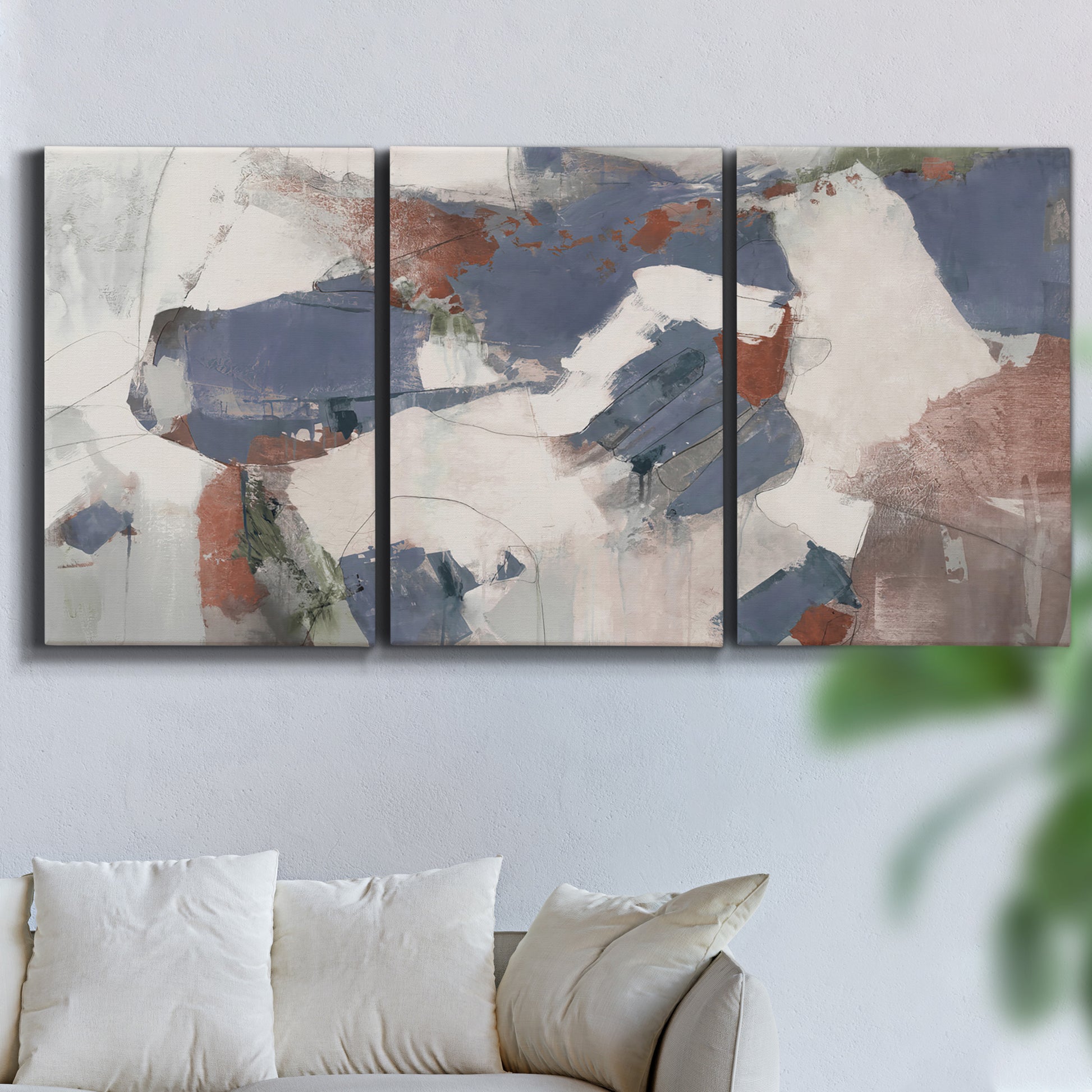 Three-panel canvas wall art featuring cool blue abstract layered composition, displayed in a living room above a sofa.