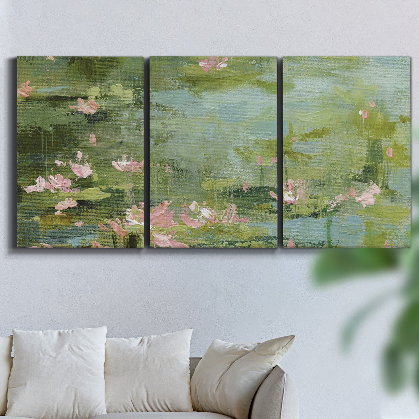 Three-panel canvas wall art featuring muted water lily pond, displayed in a living room above a sofa.