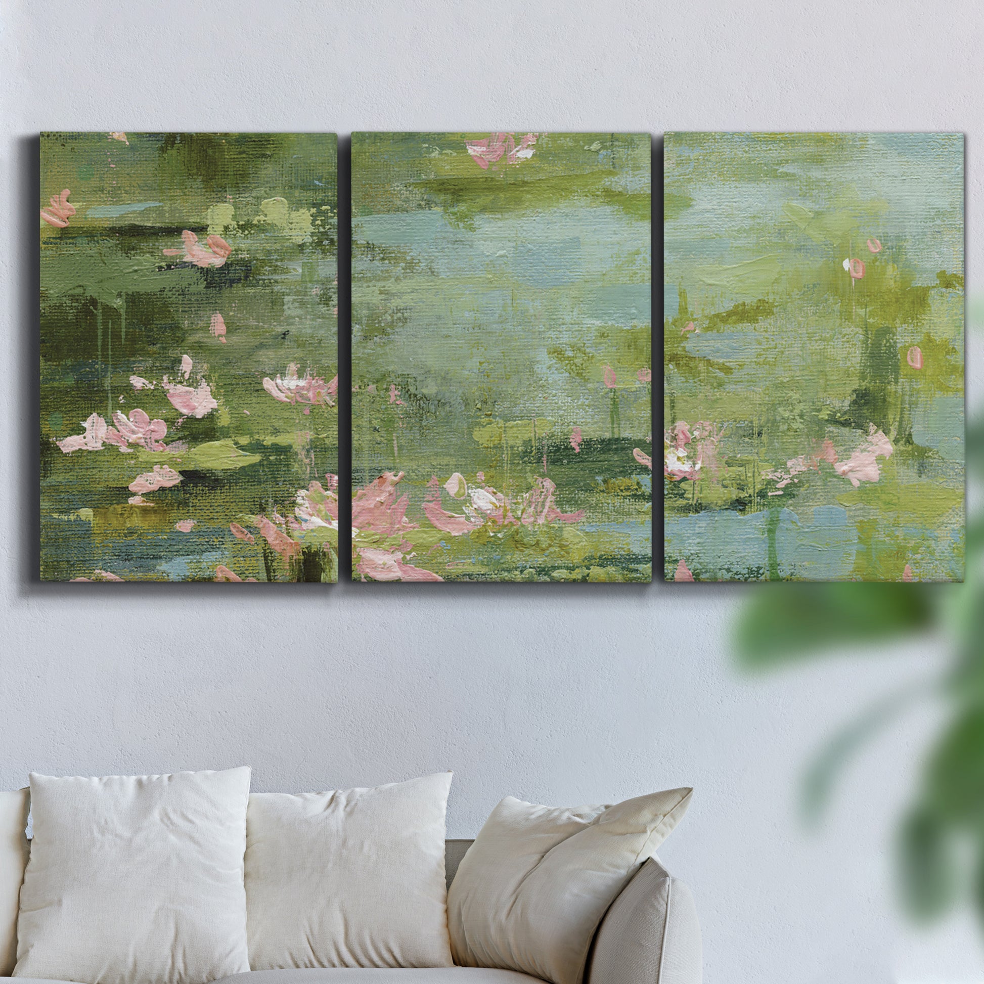 Three-panel canvas wall art featuring muted water lily pond, displayed in a living room above a sofa.
