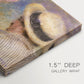 Canvas art print of a close-up of a couple seated together outdoors with hats and soft sunlight, highlighting texture and gallery-wrapped edges