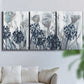 Three-panel canvas wall art featuring indigo floral abstraction, displayed in a living room above a sofa.