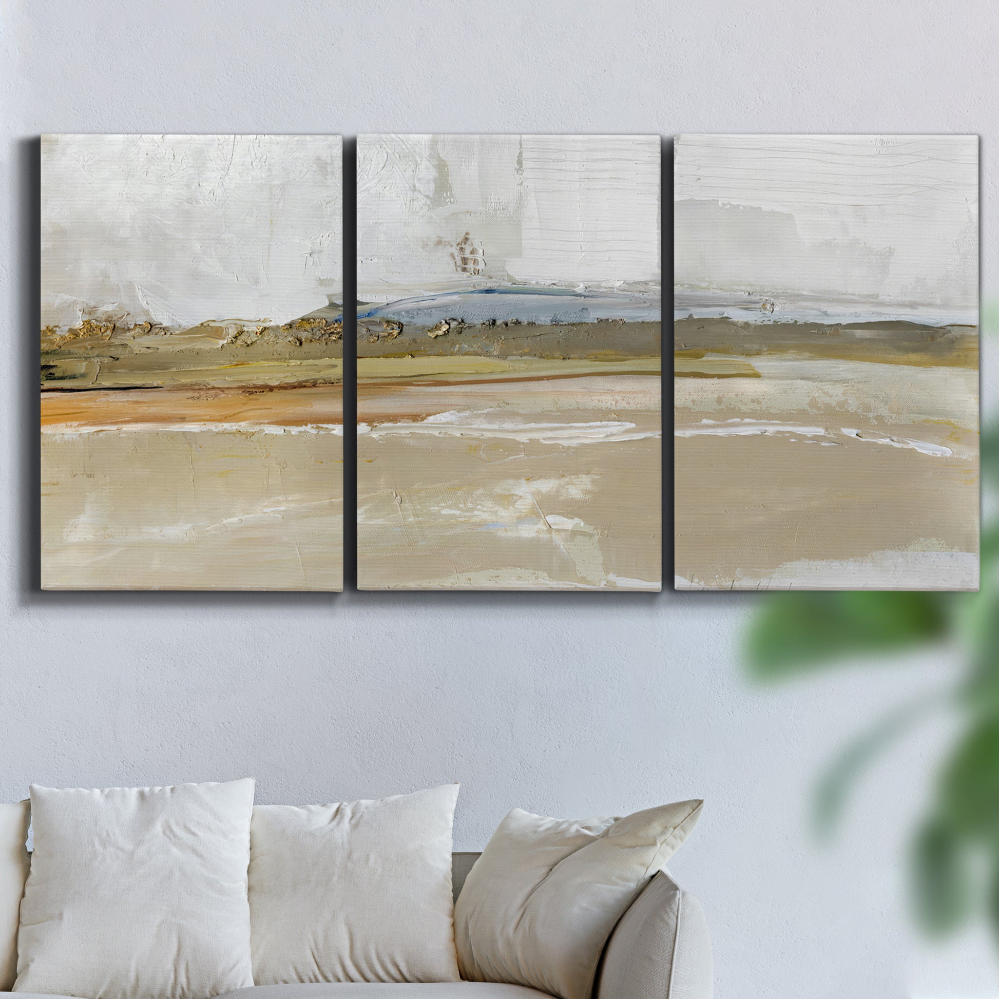 Three-panel canvas wall art featuring golden hour light over landscape, displayed in a living room above a sofa.