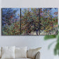 Three-panel canvas wall art featuring orchard of trees in spring bloom, displayed in a living room above a sofa.
