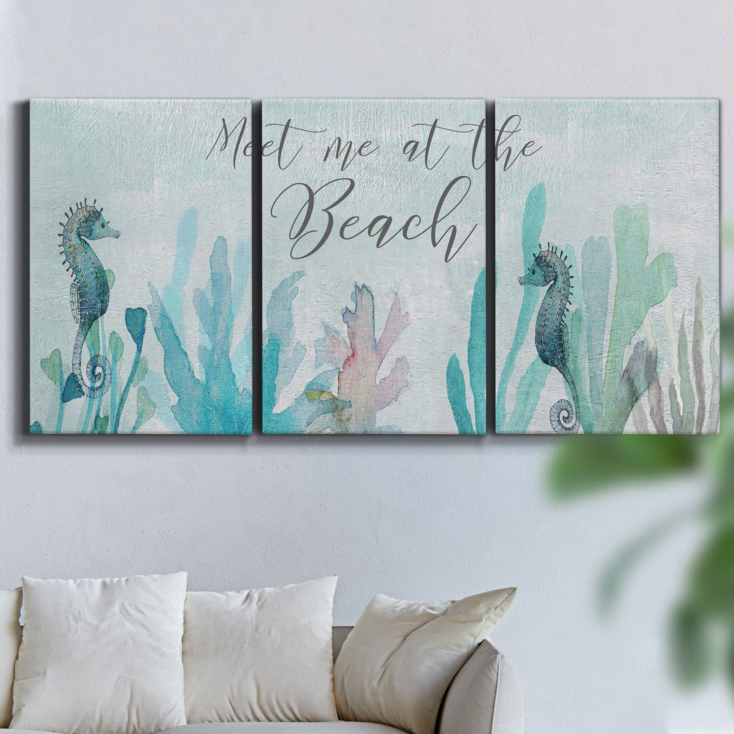Three-panel canvas wall art featuring coastal typography with seahorses, displayed in a living room above a sofa.